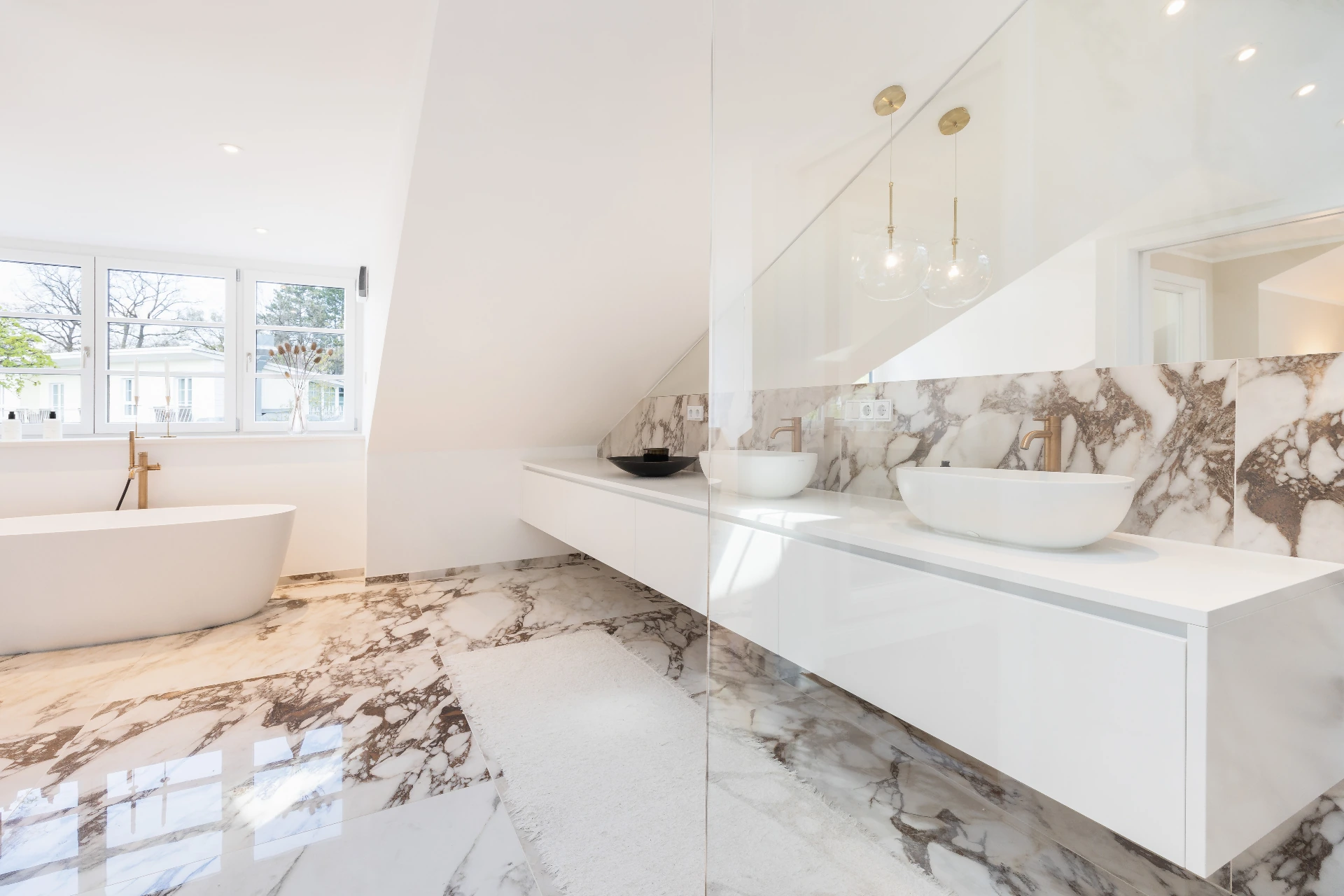 Badezimmer mit Regendusche und rundem Spiegel