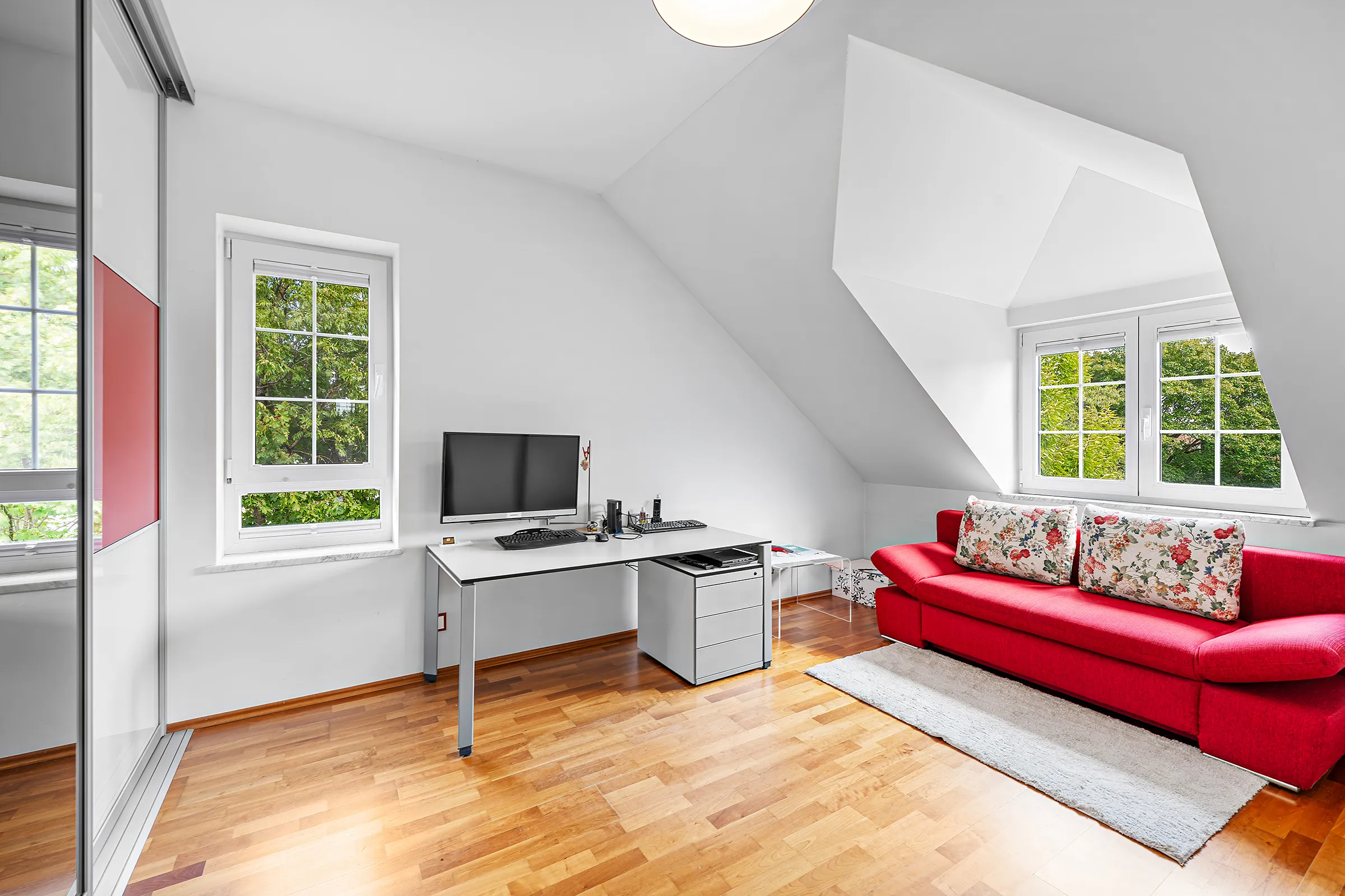 Arbeitszimmer mit Schreibtisch, rotem Sofa und Gaubenfenster, Dachgeschosswohnung Trudering