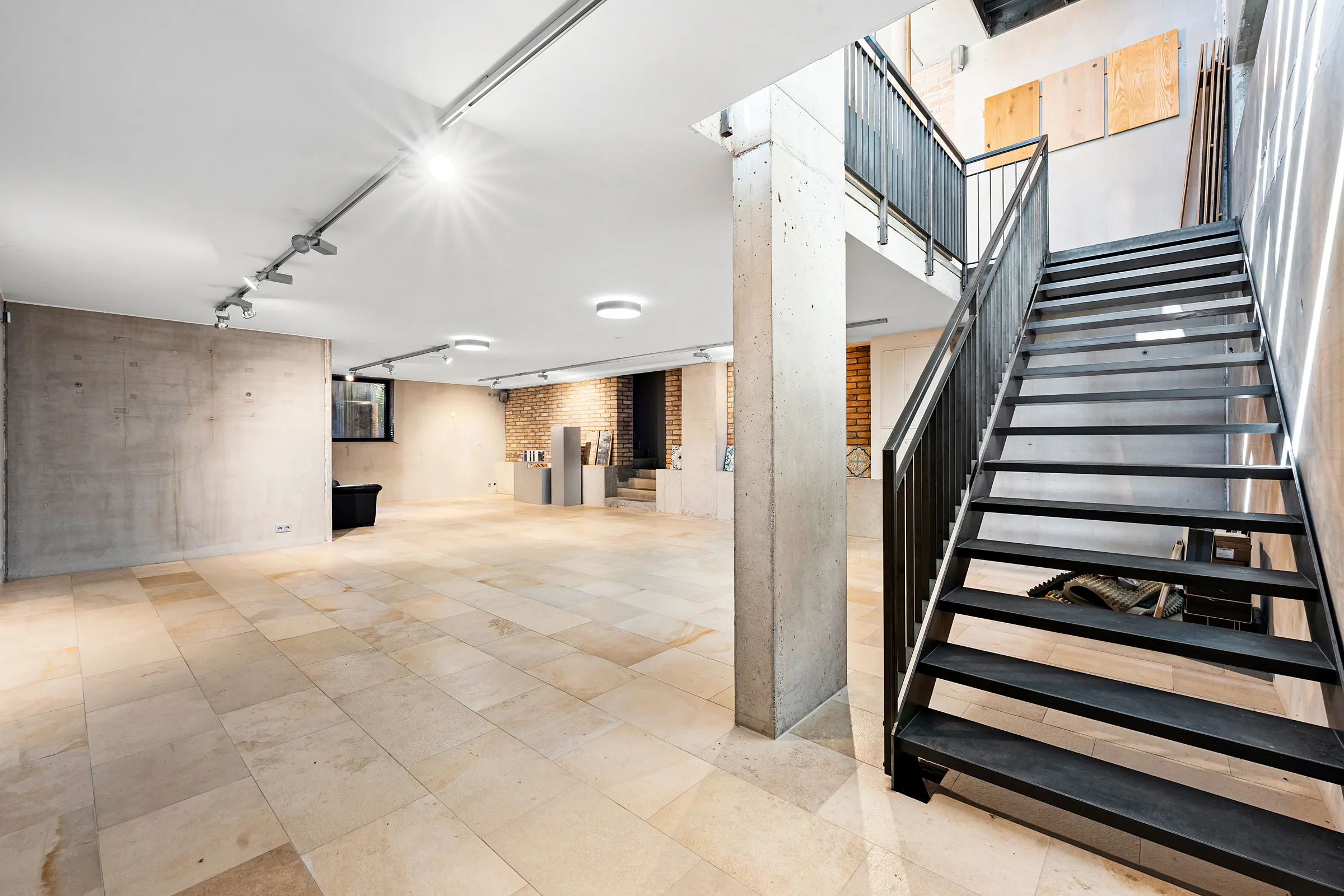 Untergeschoss mit Natursteinboden, Sichtbeton und Stahltreppe, Gewerbefläche Obermenzing