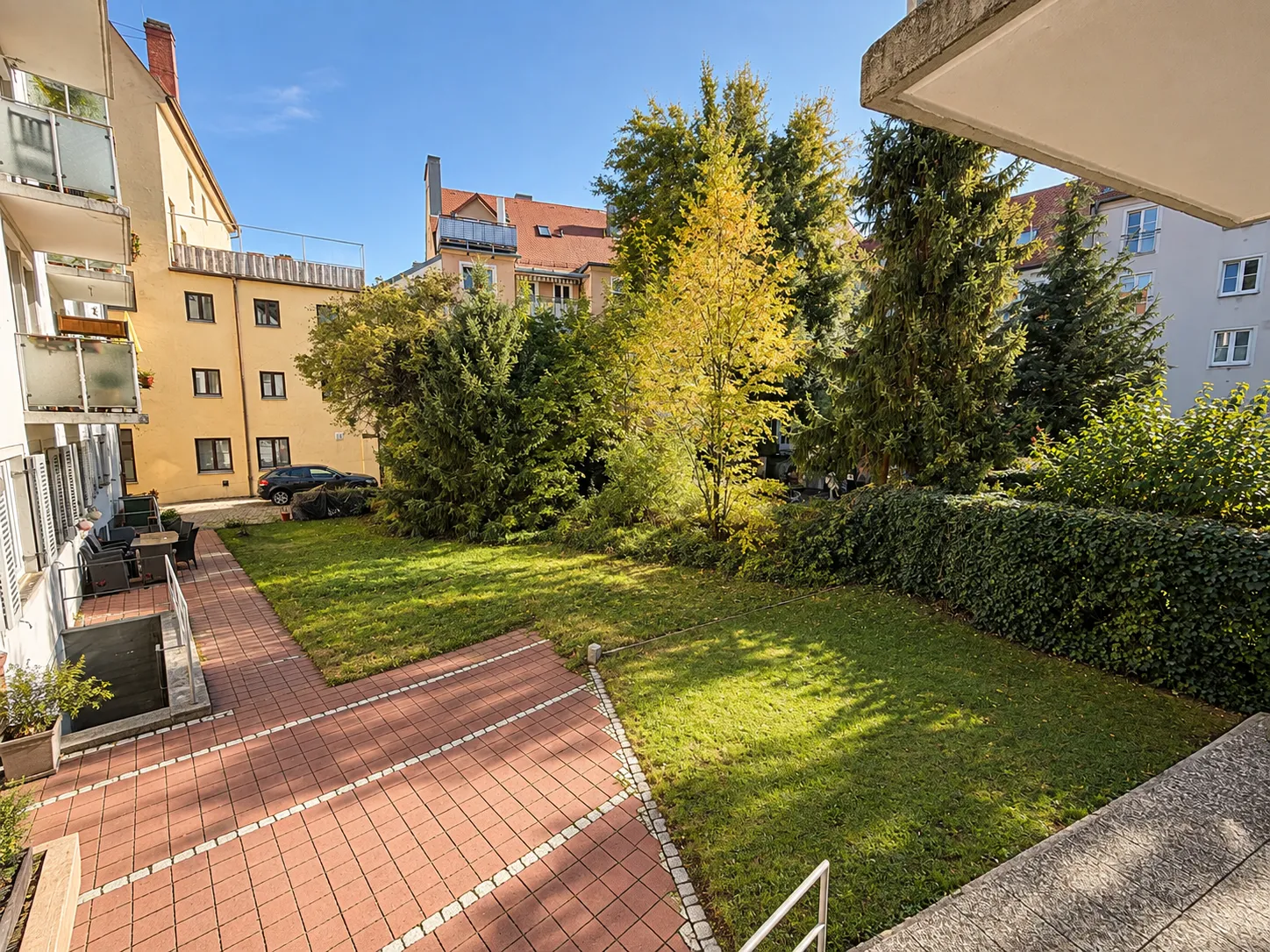 Grüner Innenhof mit Rasenfläche und Bäumen, 2-Zimmer-Wohnung Augsburg