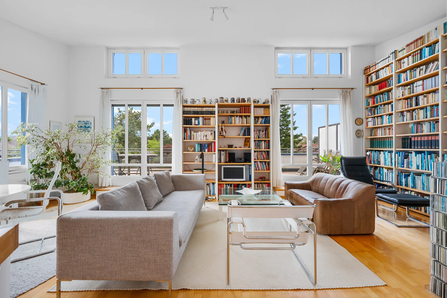 Wohnbereich unter dem Pultdach mit Bücherwand und Fensterband nach Westen