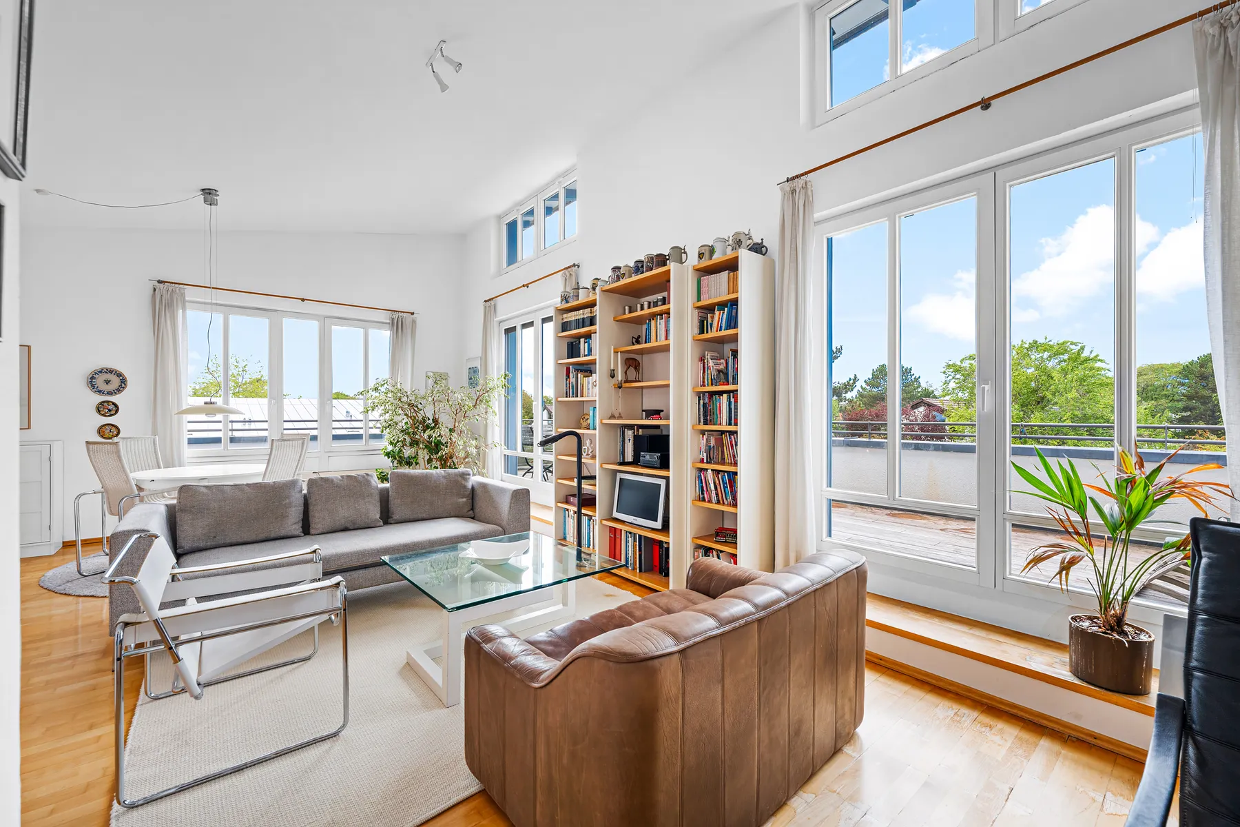 Wohnbereich mit raumhohen Fenstern und Terrassentüren zur Dachterrasse