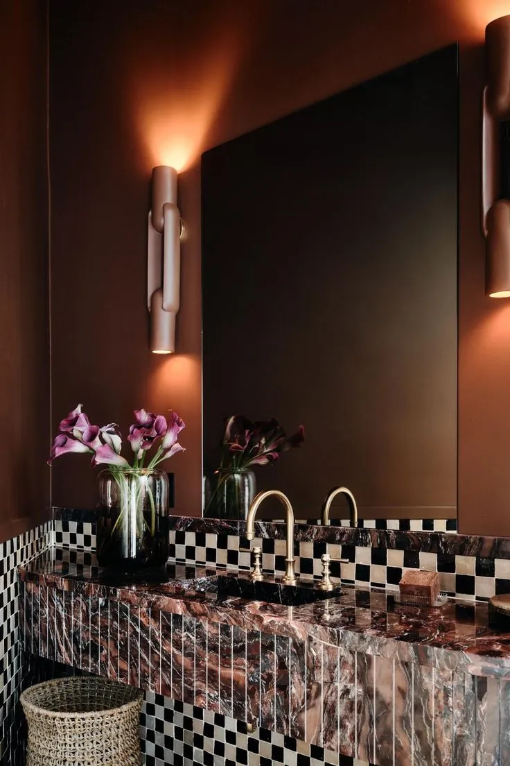 Badezimmer mit Marmorwaschtisch, Schachbrettfliesen und Wandleuchten