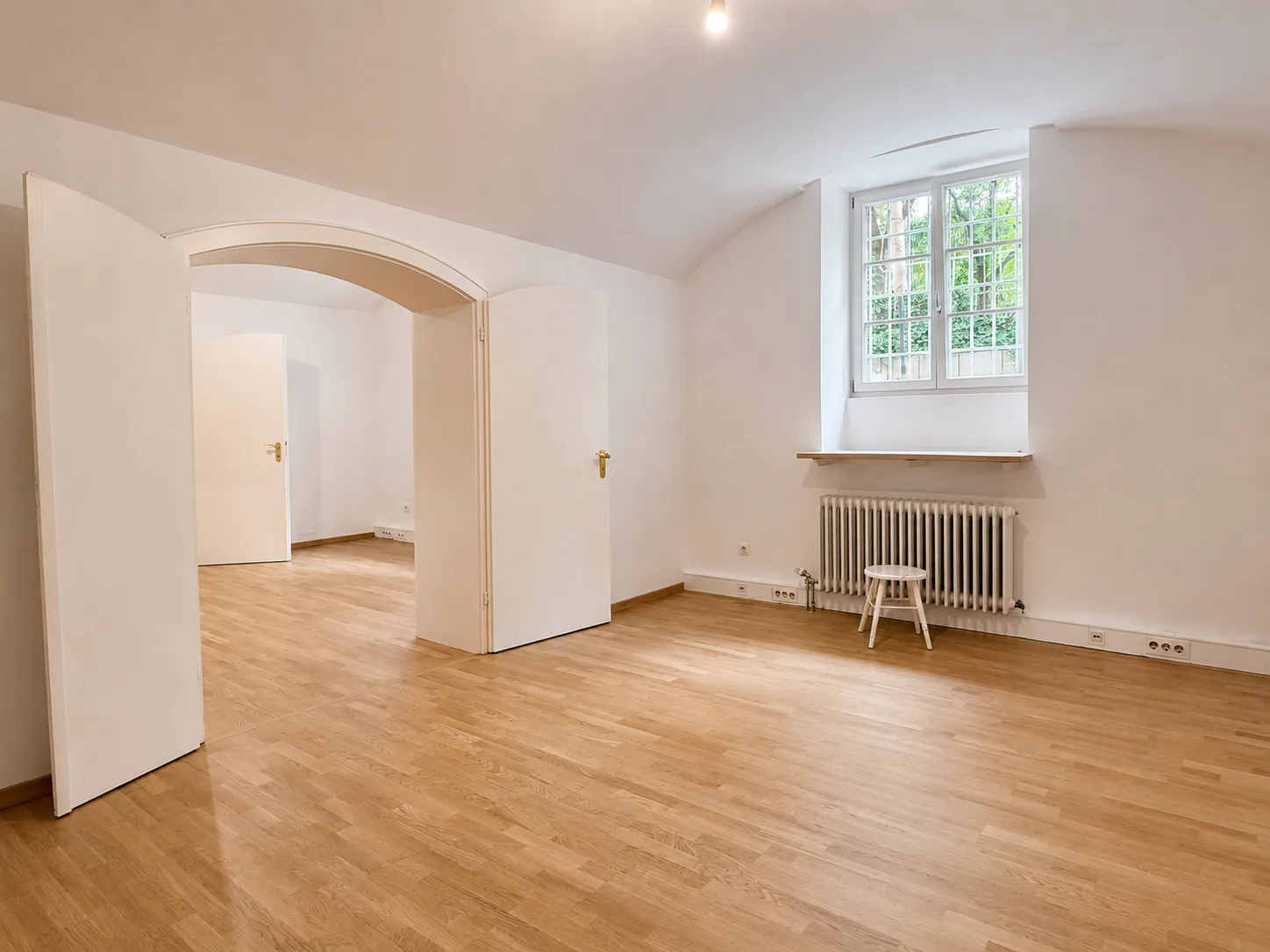 Heller Büroraum mit Fenster zum Innenhof