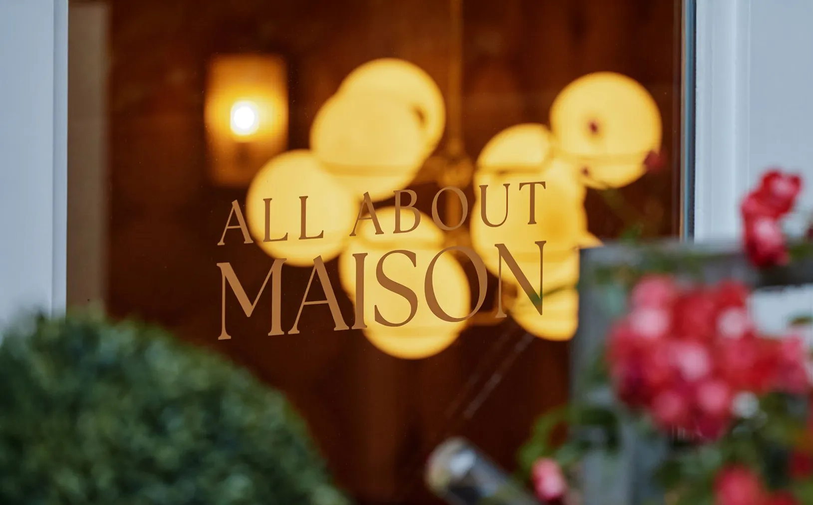 Fenster mit All About Maison Schriftzug